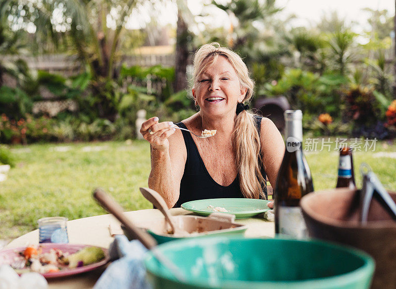 夏天，一家人在户外露台上一起吃饭，主要是老年成年女性