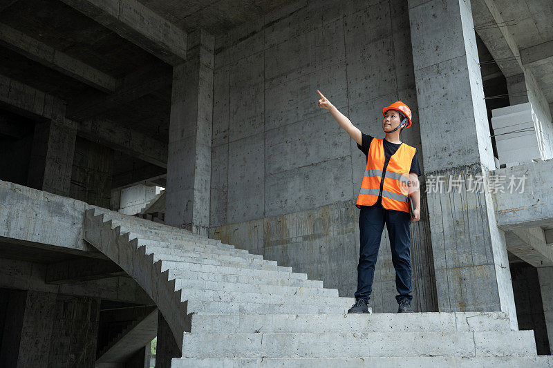 一位女工程师走下一个未完工的建筑工地的楼梯