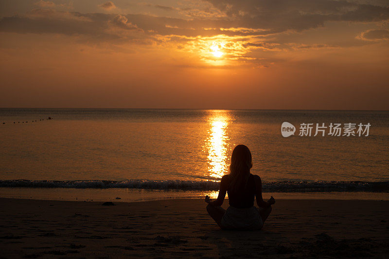 瑜伽和冥想平静宁静的海滩日落适合年轻女子