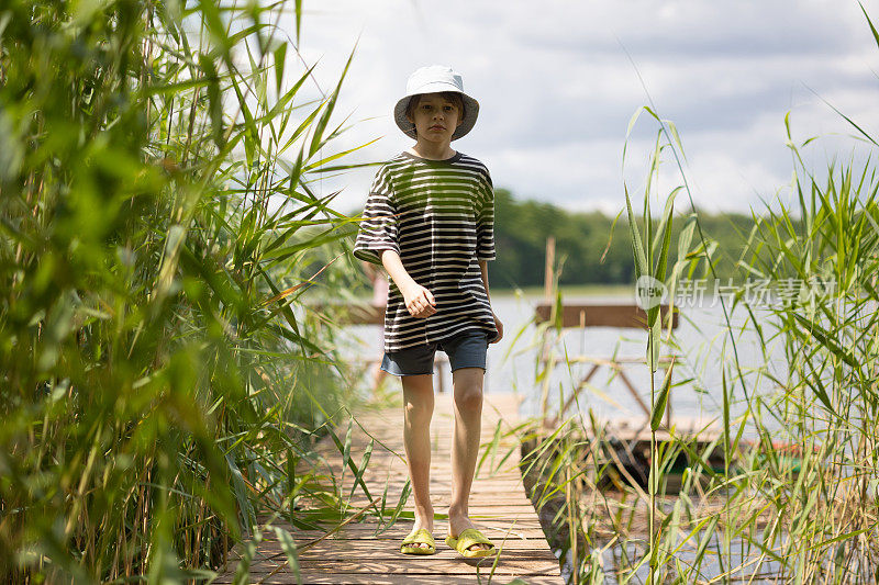 小男孩在湖边的码头上