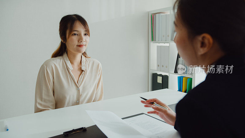 年轻的亚洲女性通过面试，坐在办公室的人力资源经理面前。人力资源，招聘机构。