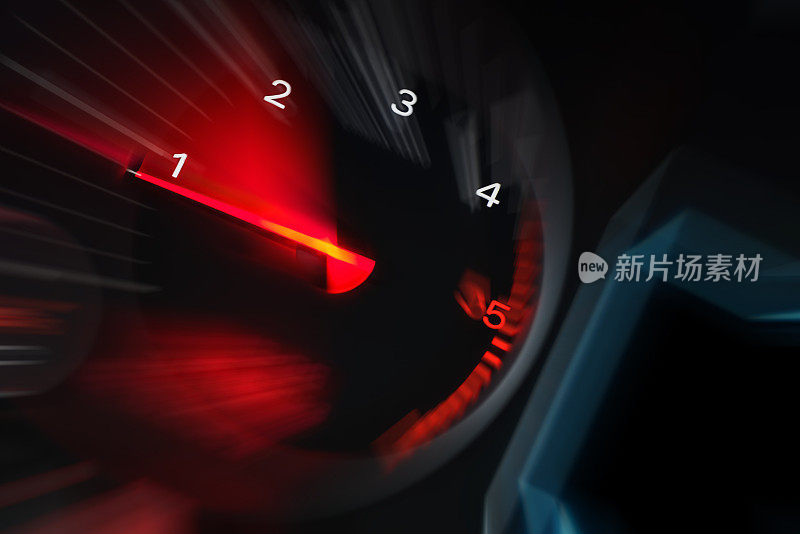 运动模糊的汽车仪表盘里程表与红色照明显示。汽车速度表。高速汽车测速仪和夜间运动模糊。