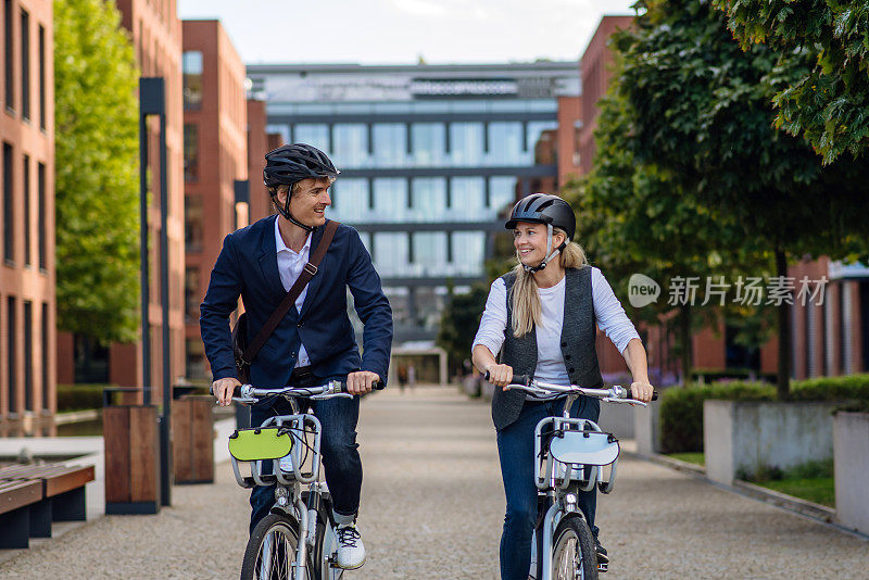 夫妻在城市里穿梭，在街上骑自行车。在漫长的工作日后骑自行车下班的中年城市上班族。