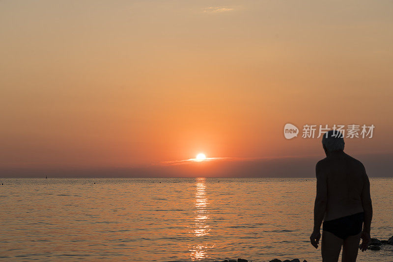 人们在海边浪漫的夕阳下沉思