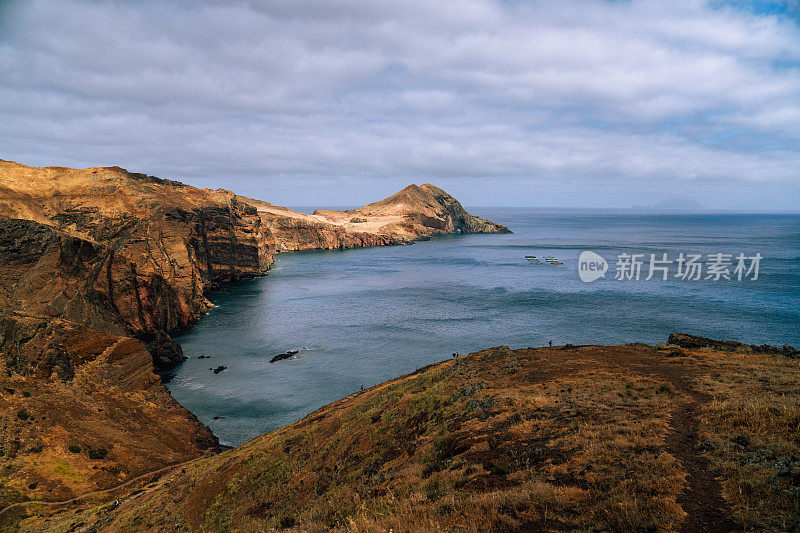 岩石陡峭的悬崖和山脉在平静的海边。马德拉岛天然绿松石般的海岸线