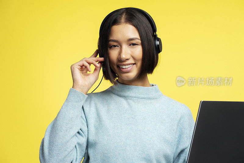 微笑的亚洲女人的画像，呼叫中心接线员戴着耳机。在线交流
