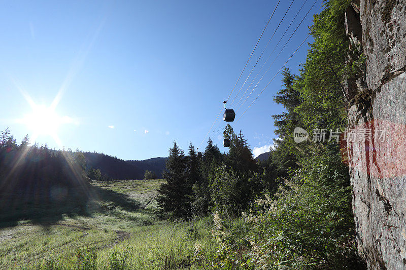 贡多拉在草地和岩面上方的山坡上移动