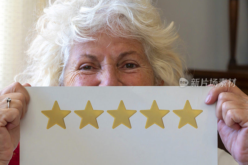 快乐的老年妇女显示笑脸卡为良好的服务评价。