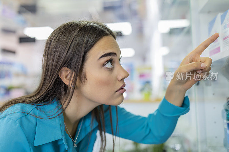 美丽的女人在药店购物