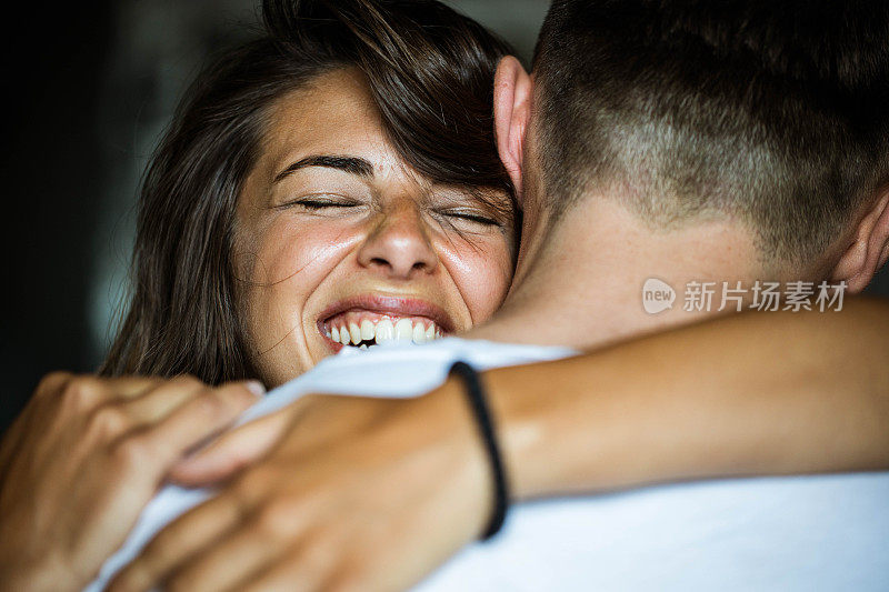 幸福的女人闭着眼睛拥抱着她的男朋友。