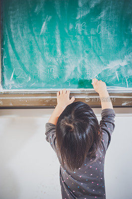 一个中国女孩在黑板上写字