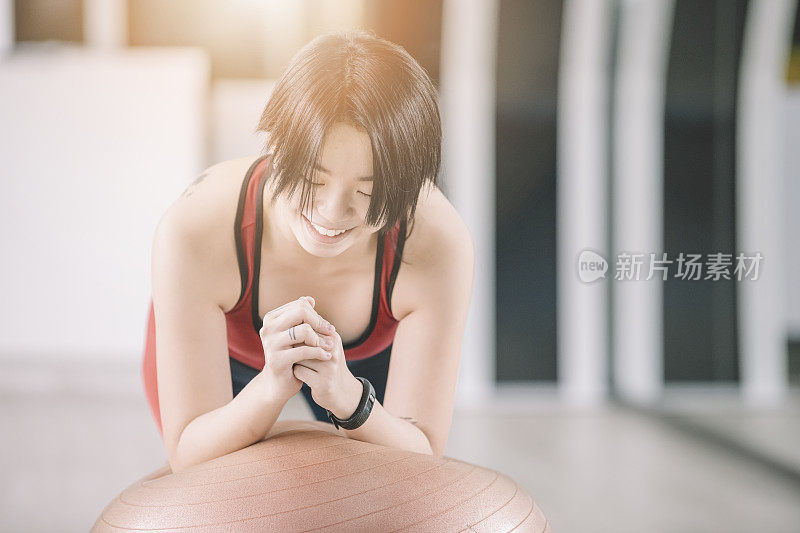 一位亚洲华裔少女用普拉多健身球做平板支撑