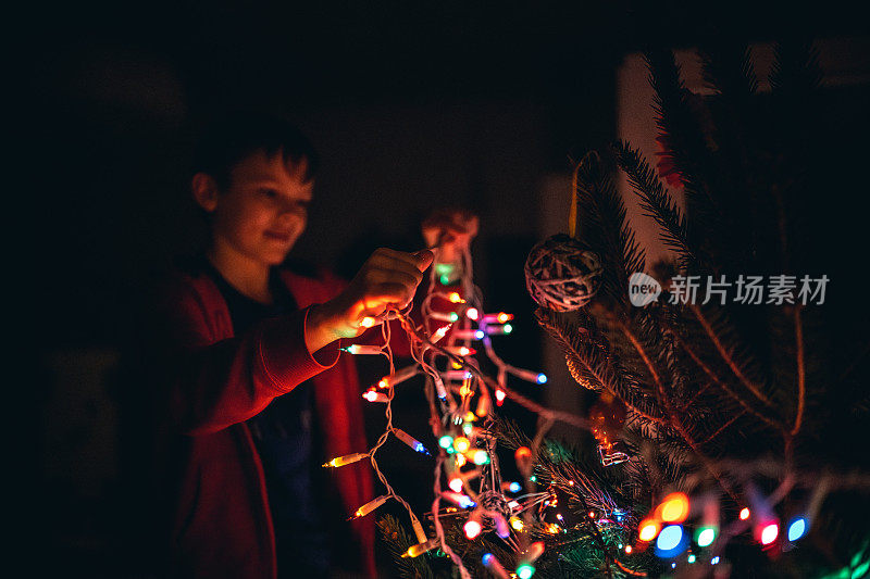 男孩在家里装饰圣诞树