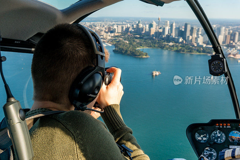 一名白人男子在直升机上拍摄悉尼CBD和悉尼港
