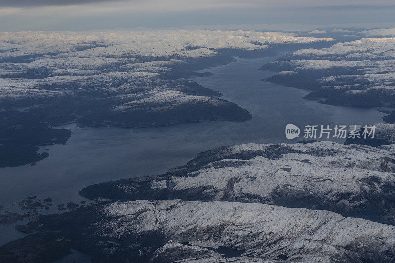 乘客从飞机上俯瞰挪威的峡湾，山上覆盖着积雪