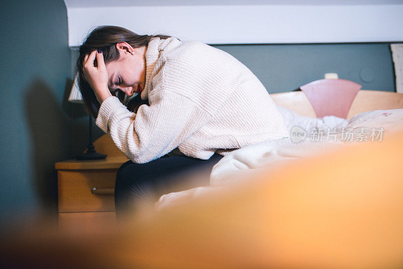 抑郁的女人在床上的肖像