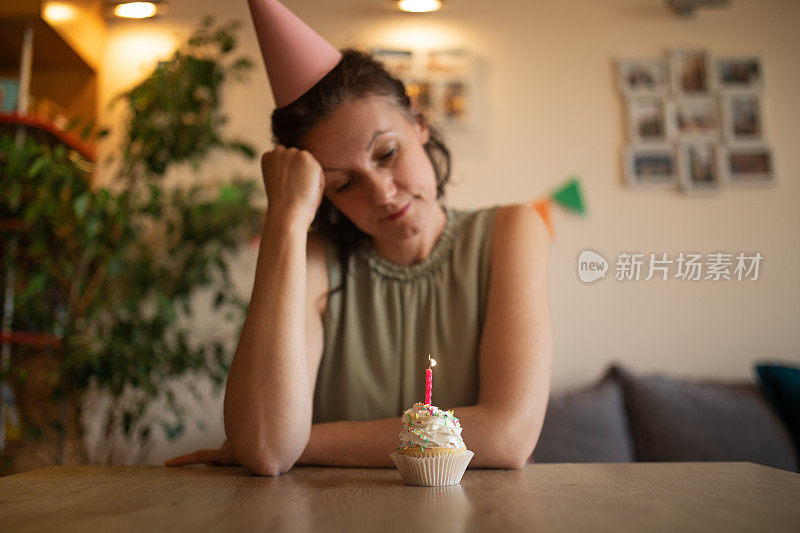不幸的女人独自在家庆祝生日