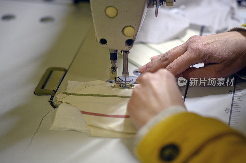 女人用缝纫机缝制防护口罩的特写