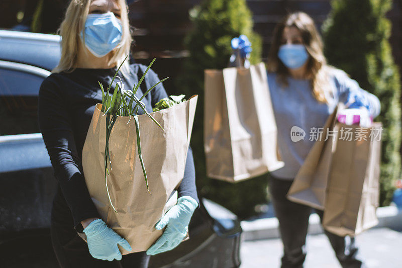 买菜回家的女人。戴上防护口罩和手套