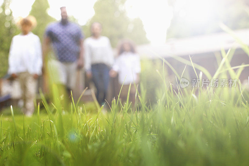 非裔美国人家庭在后院草坪散步的散焦表面水平肖像
