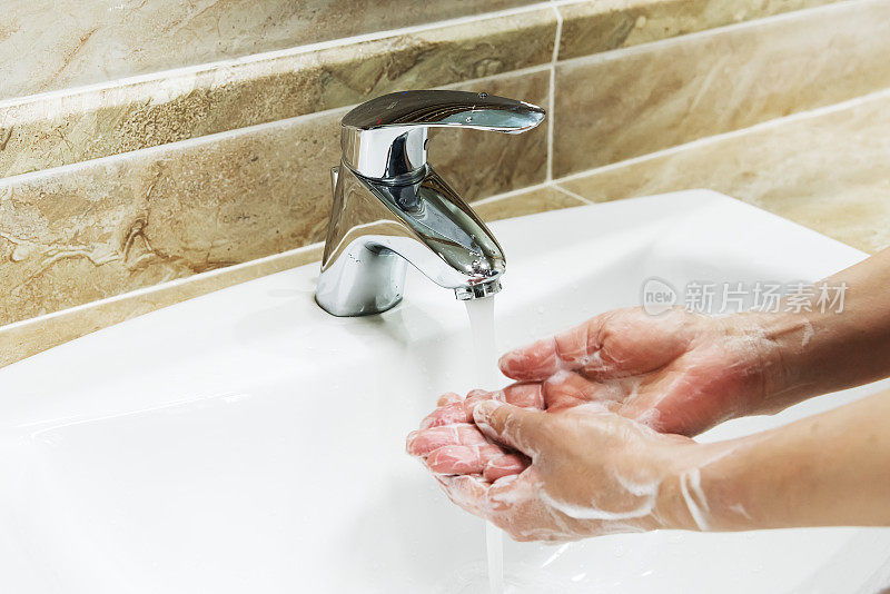 一个女人用肥皂水洗手的特写