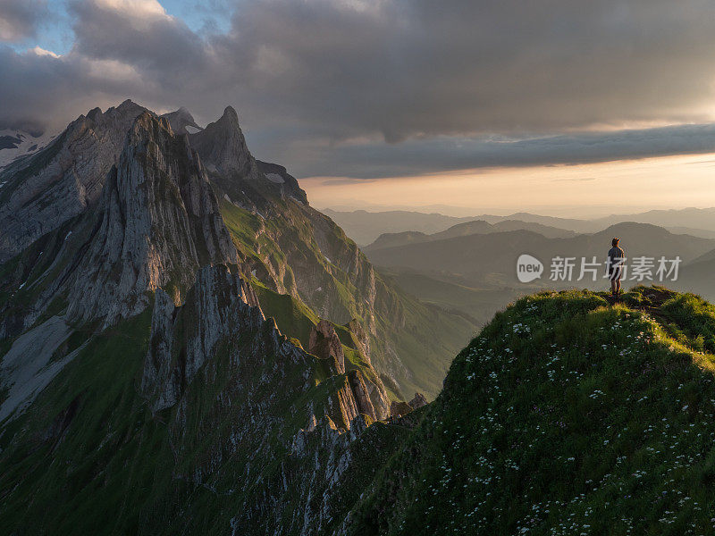 一名男子在瑞士徒步旅行，然后停下来看风景