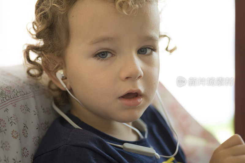 蹒跚学步的孩子听着歌曲耳机唱歌