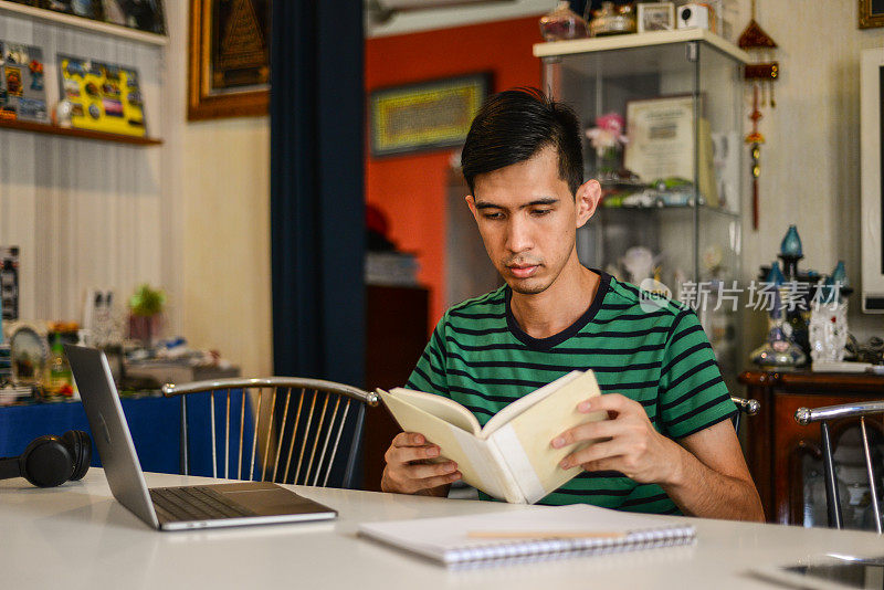 亚洲男学生使用电脑在家学习