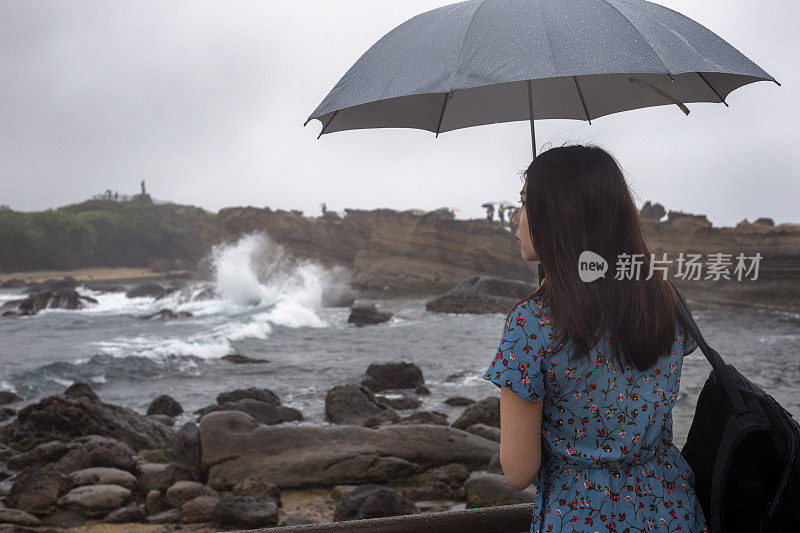 亚洲女游客在台湾野柳地质公园看美丽的海景