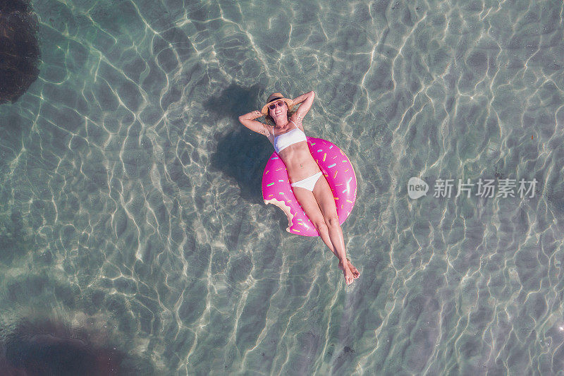 鸟瞰图上的女人漂浮在湖上充气床垫日光浴