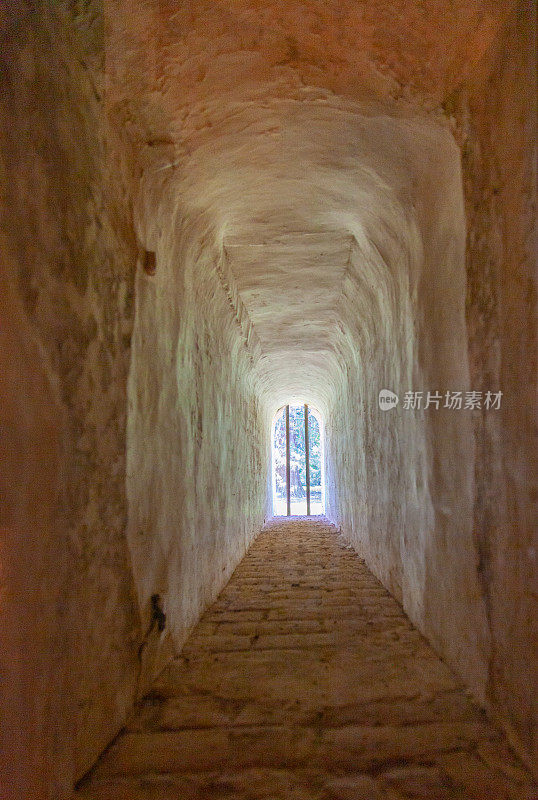 隧道尽头的光线——一个通向中世纪建筑窗户的狭窄隧道上的抽象视图