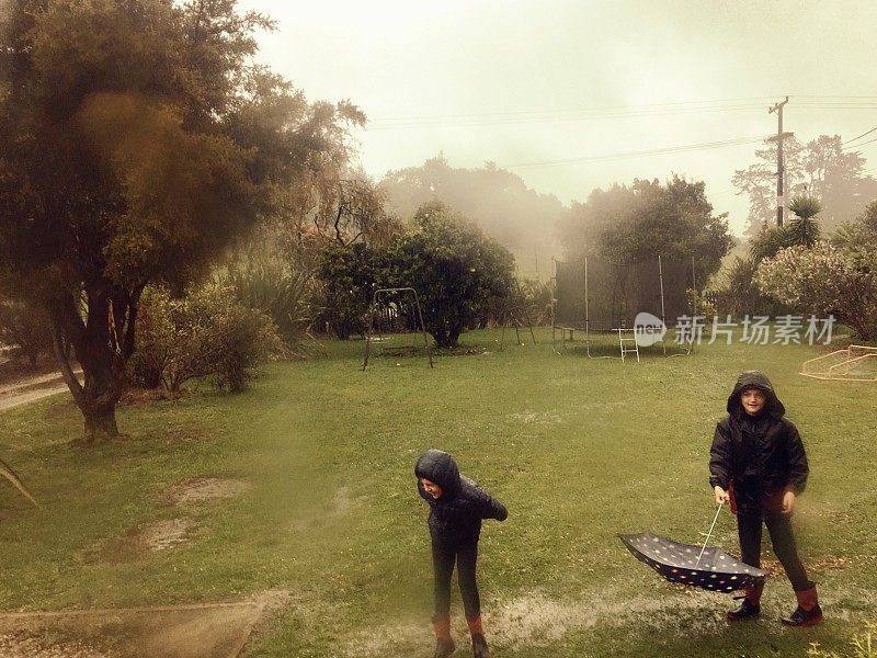 孩子们在花园里的雨中玩耍