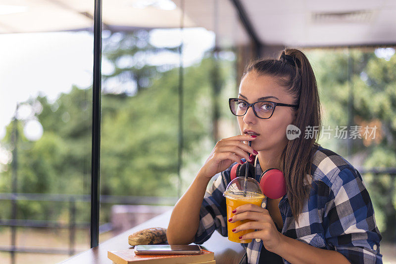 一个在快餐店里拿着书的年轻女子