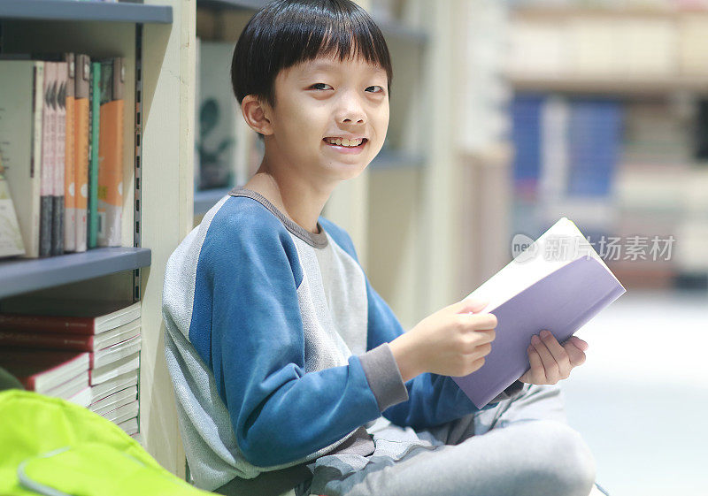 快乐的亚洲孩子在图书馆看书