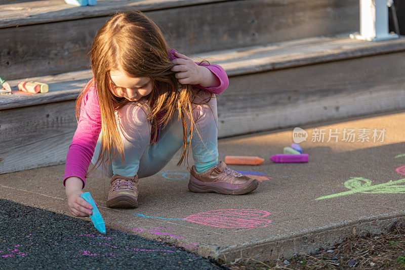 女孩在前廊用粉笔画画
