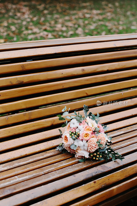 木凳上放着一束粉红色、桃花、玫瑰和牡丹。