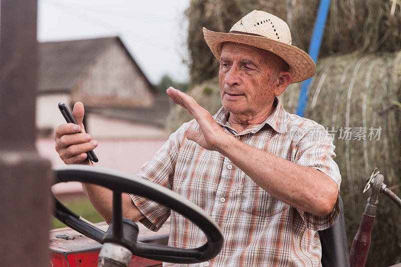 老年农民驾驶拖拉机时可以通过智能手机进行视频通话
