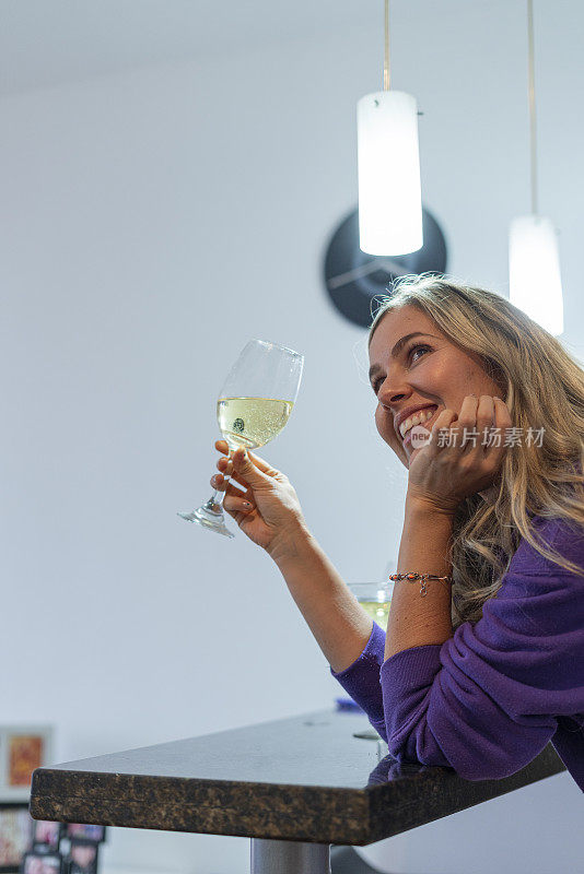 拉丁女子喜欢微笑着喝白葡萄酒，在家里穿着睡衣，想着积极的事情，享受她最亲密的时刻