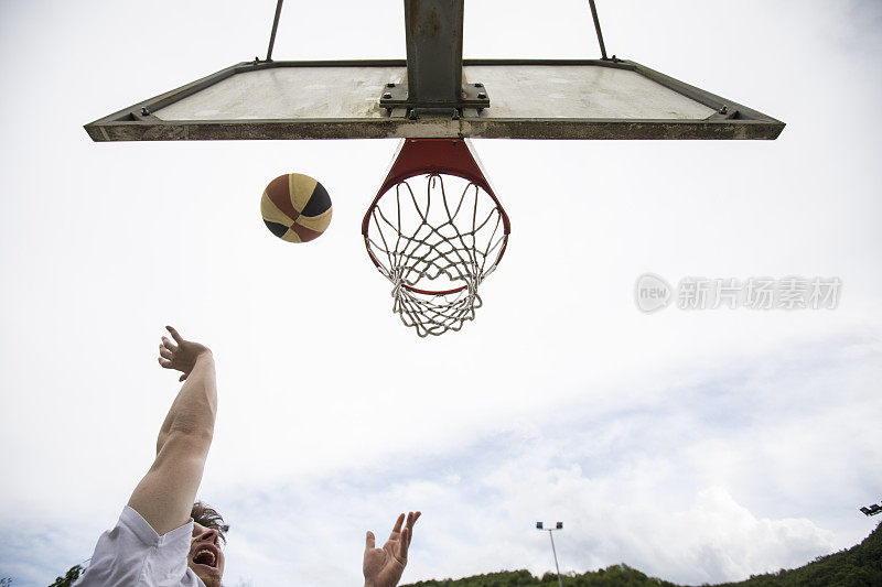 从低角度看篮球场上的年轻人上篮
