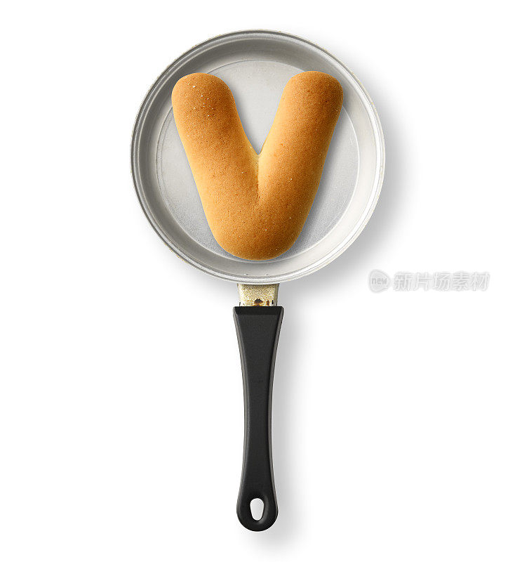 孤立的镜头的大写字母饼干V在一个旧的玩具煎锅，在白色的背景