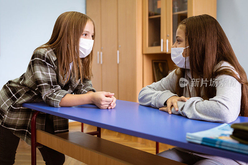 两个女孩在教室里谈话