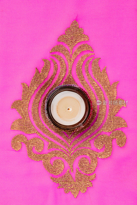 点燃的蜡烛从上面的彩色粉红色和金色印度教纱丽绳