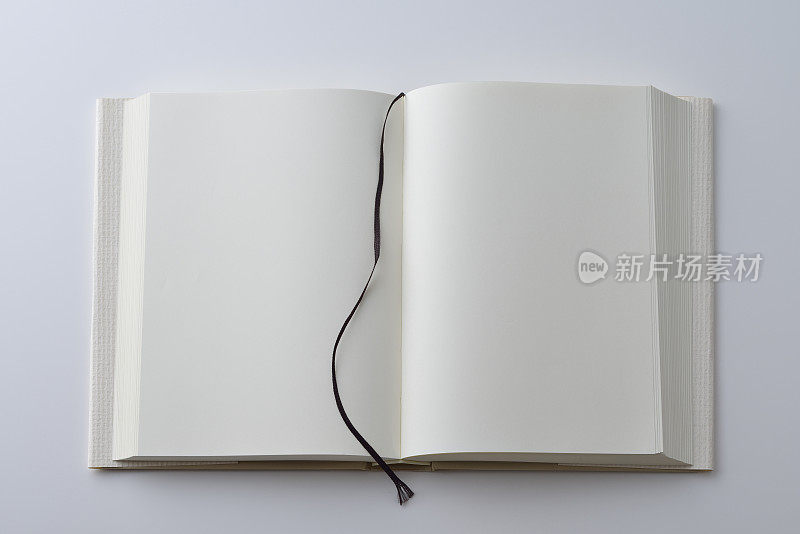 翻开的书的空白页，封面在白色背景上