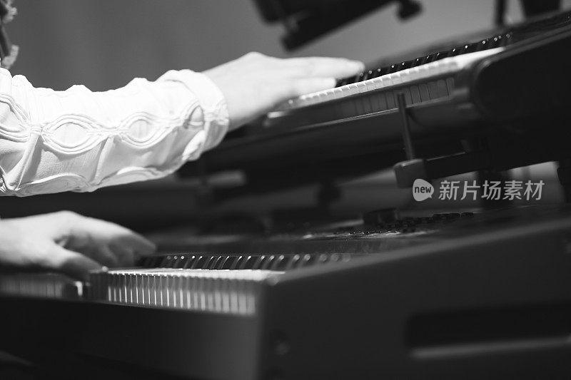 电子钢琴演奏者在两个键盘上演奏