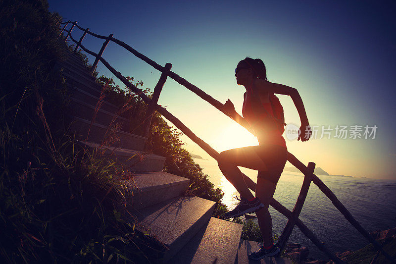 年轻的健身女运动员在山上的楼梯上跑步