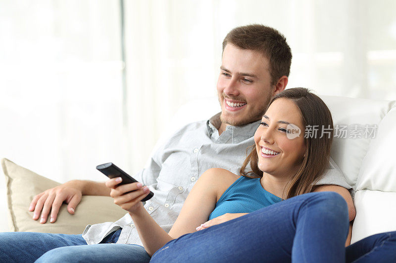 一对幸福的夫妇在家里看电视
