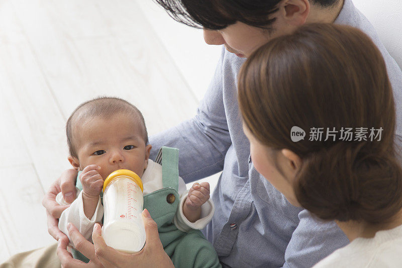 一对日本夫妇用奶瓶给婴儿喂奶