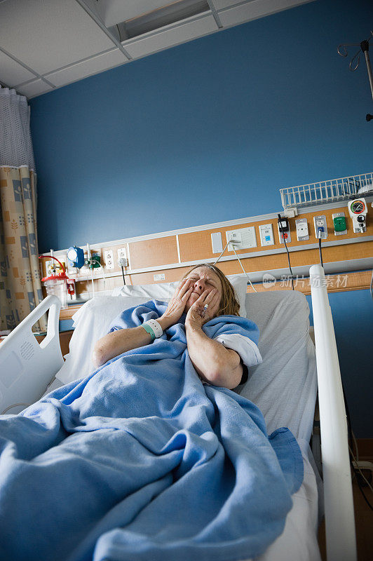 躺在医院病床上的痛苦女人