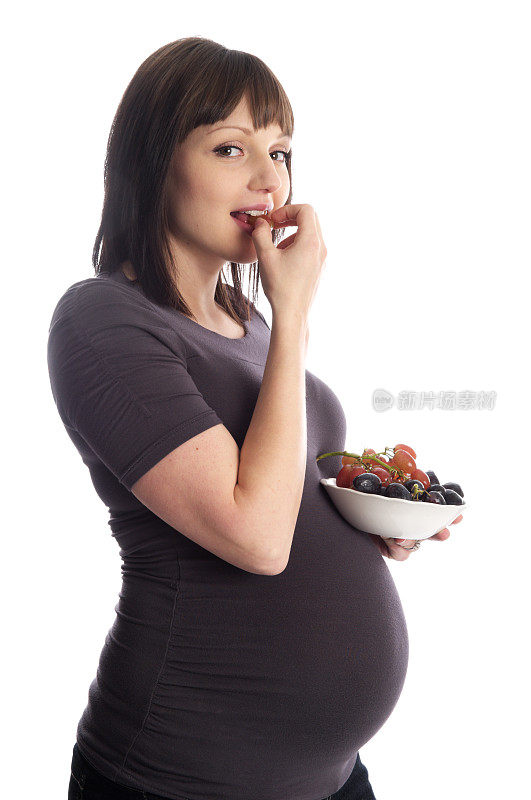 孕妇吃葡萄的侧面图。