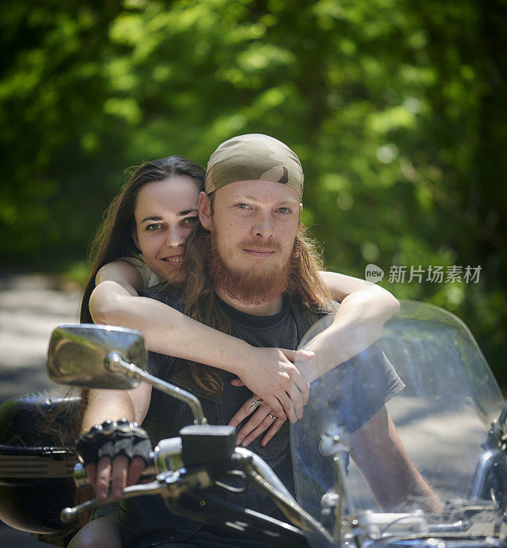 年轻幸福的夫妇骑着摩托车